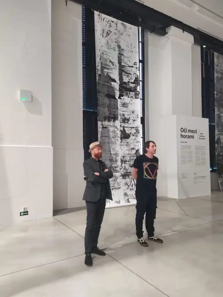 Artist Patrik Hábl and curator Jan Kunze standing in front of the exhibition "Eyes Between Mountains" at EPO1 Gallery in Trutnov.
