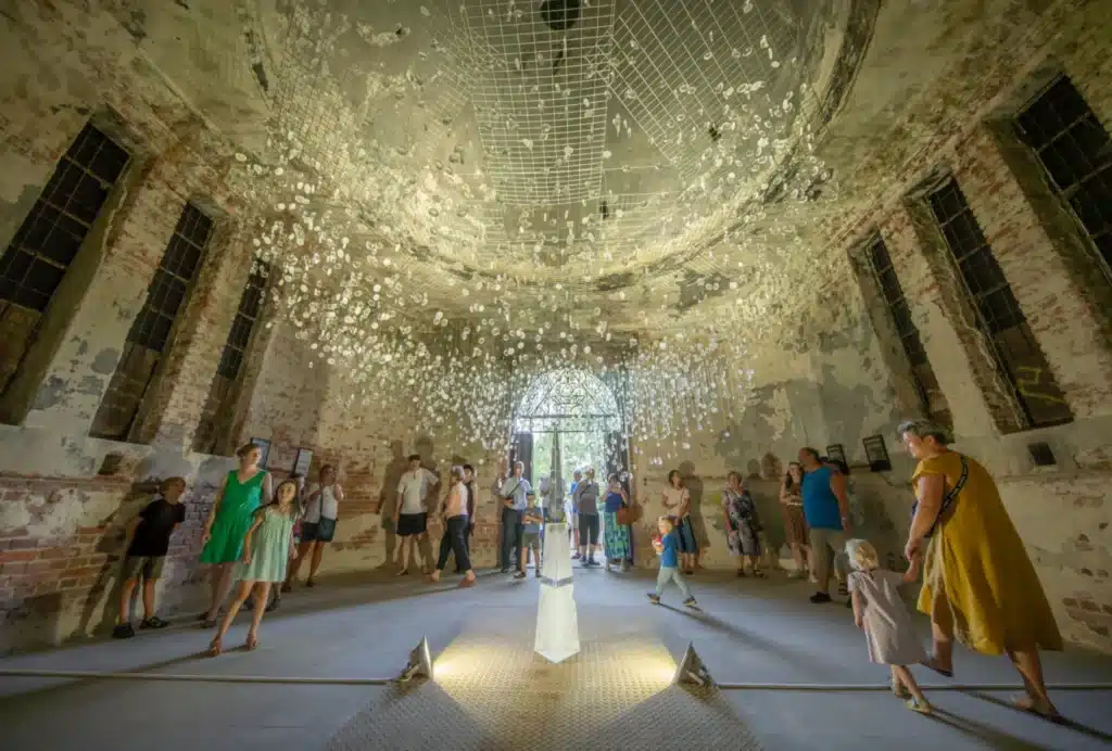 Visitors viewing a suspended glass installation by Vágner Studio inside Müller’s Tomb in Hrádek nad Nisou.